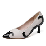 A close-up of a black satin high heel shoe with a pointed toe and a slender heel, featuring an embroidered white skull pattern and a dragonfly embellishment on the side.