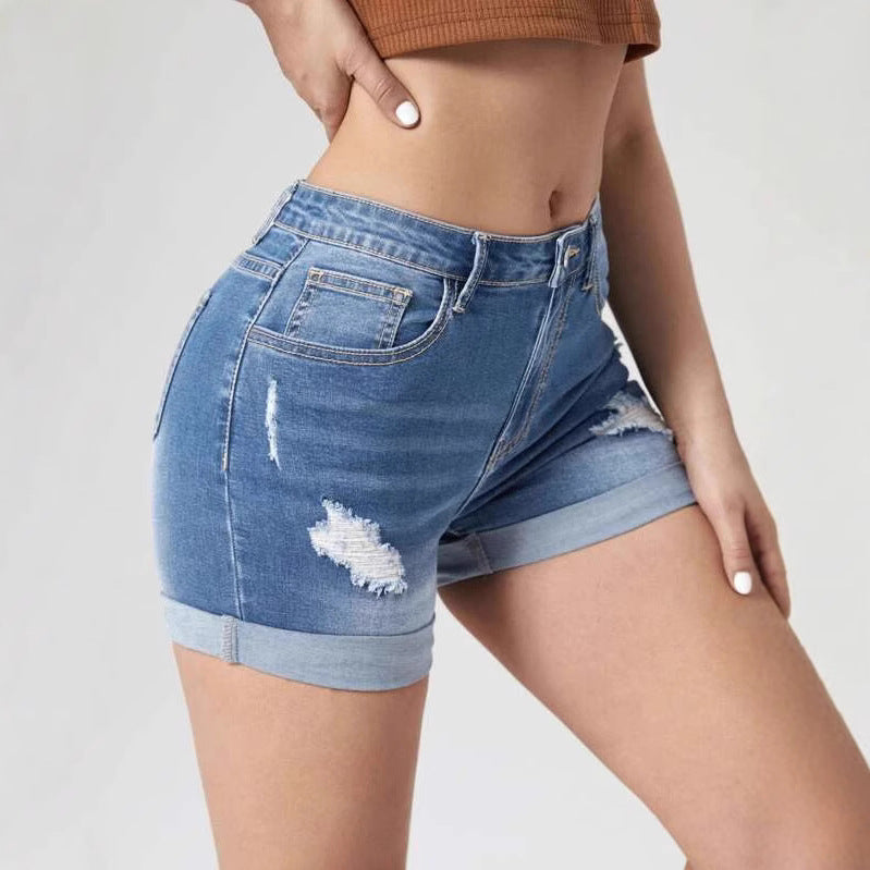 A pair of light blue, high-waisted denim shorts with distressed holes and a cuffed hem. The shorts have a skinny fit and are displayed on a flat surface.