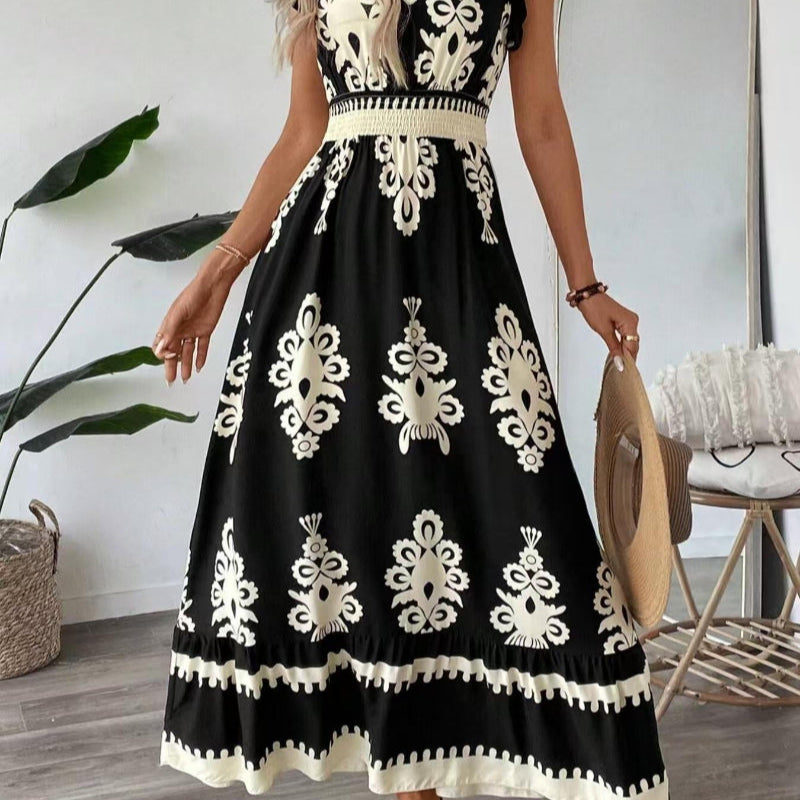 A stylish model wearing an elegant floral V-neck midi dress in a dark blue color. The dress has a waist-cinched design and a beautiful positional flower pattern, perfect for an elegant commuting style.