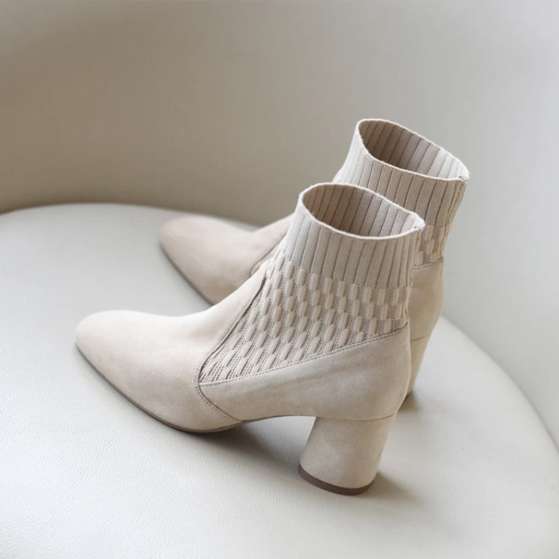  A pair of black casual lightweight ankle heel boots with a thick heel, against a neutral background