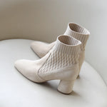  A pair of black casual lightweight ankle heel boots with a thick heel, against a neutral background