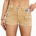 Model wearing high-waisted khaki denim shorts in street style setting, casual look with sleeveless top.