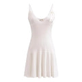 A sleeveless, V-neck, A-line mini dress in a criss-cross knitted pattern, adorned with floral appliques, available in pink and white, with a backless design.