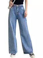 Woman wearing slim high-waisted light blue non-stretch denim jeans with a tucked-in blouse in a cityscape.