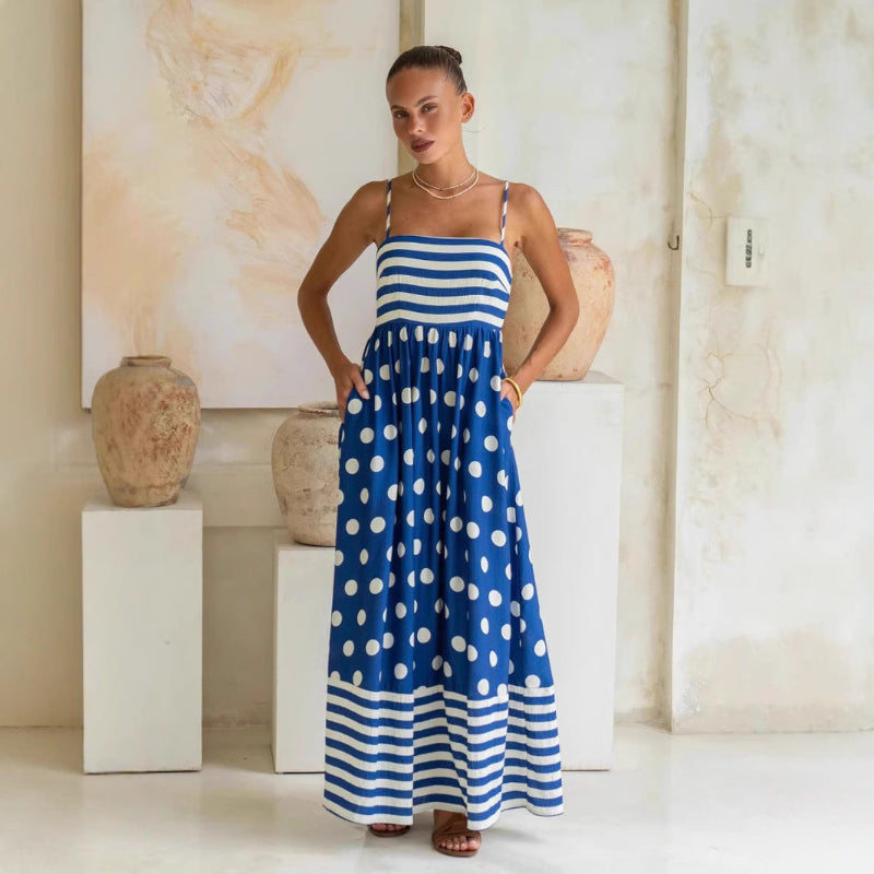 A sleeveless, high-waisted, midi-length dress with a printed pattern and a one-shoulder, backless design, photographed on a white background.