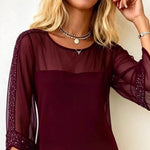 Maroon dress with sheer sleeves worn by a person, against a neutral background