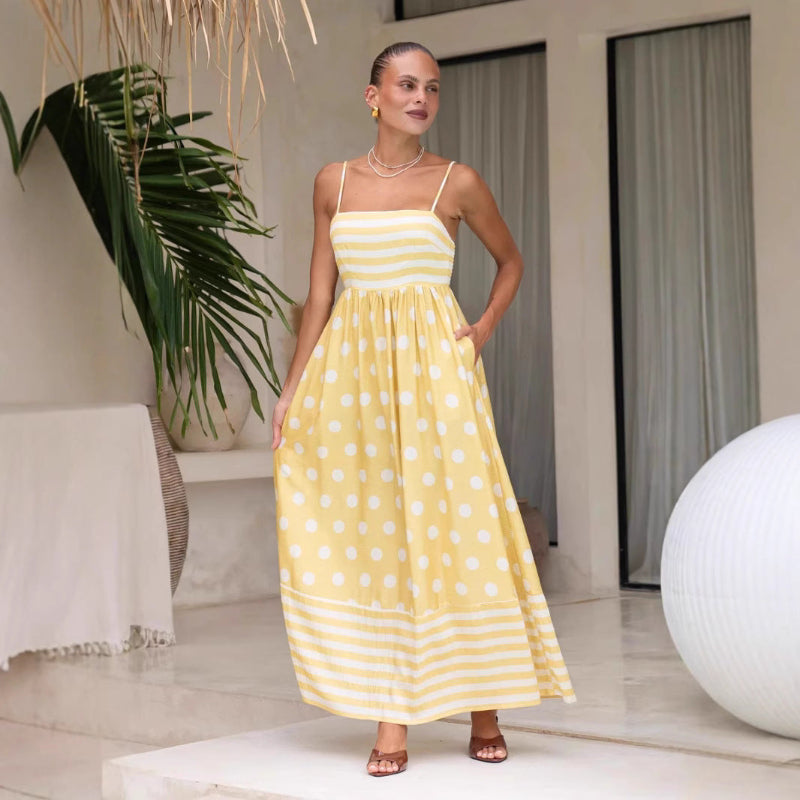 A sleeveless, high-waisted, midi-length dress with a printed pattern and a one-shoulder, backless design, photographed on a white background.