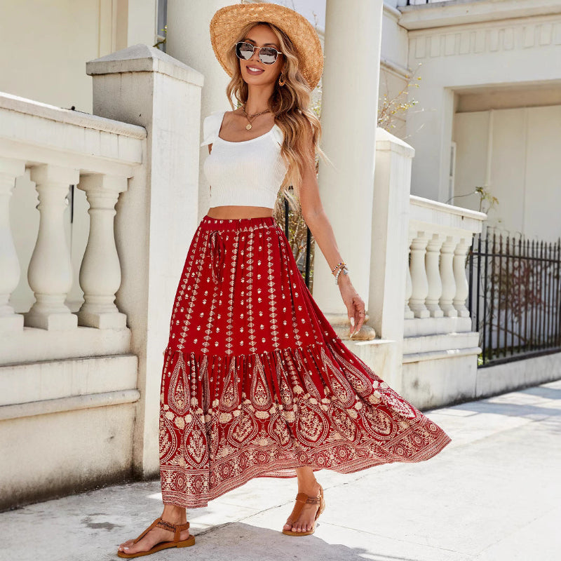 A woman wearing a vibrant, red, flared hem midi skirt with a high waist and pleated details.