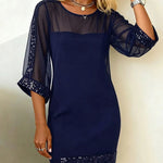 Navy blue dress with sheer sleeves and hem on a plain background