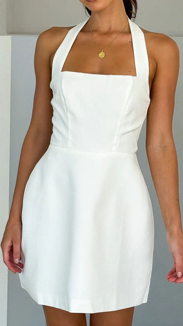 A model wearing a solid color short halter dress with a one-shoulder design.