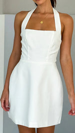 A model wearing a solid color short halter dress with a one-shoulder design.