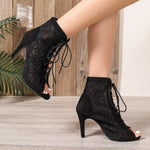A pair of black, ultra-high, slim high-heeled mesh sandal boots with a fish-mouth toe.