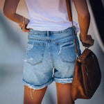 A pair of light blue, mid-waist denim shorts with a straight-leg, wide-leg fit. The shorts feature ripped and distressed details, showcasing a casual street-style look.