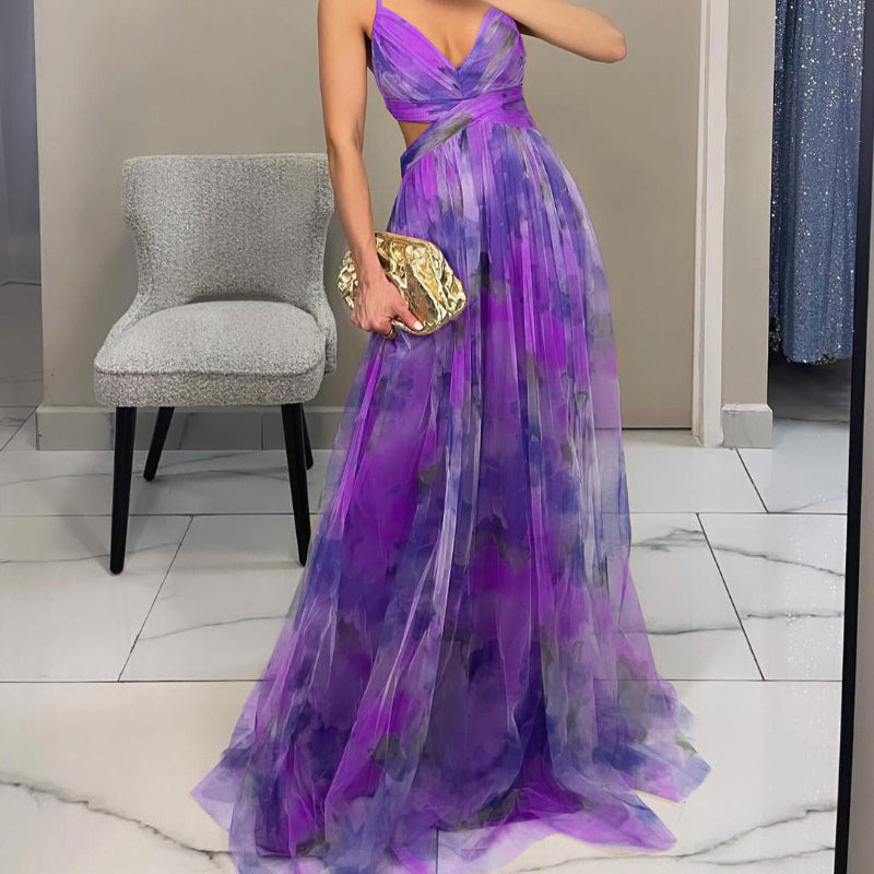 Woman wearing a strapless maxi dress with vibrant abstract print, holding gold clutch