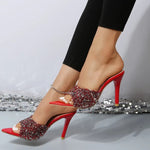 A close-up of a pair of sparkling sequin point toe mid-heel sandals in white, scarlet and black.