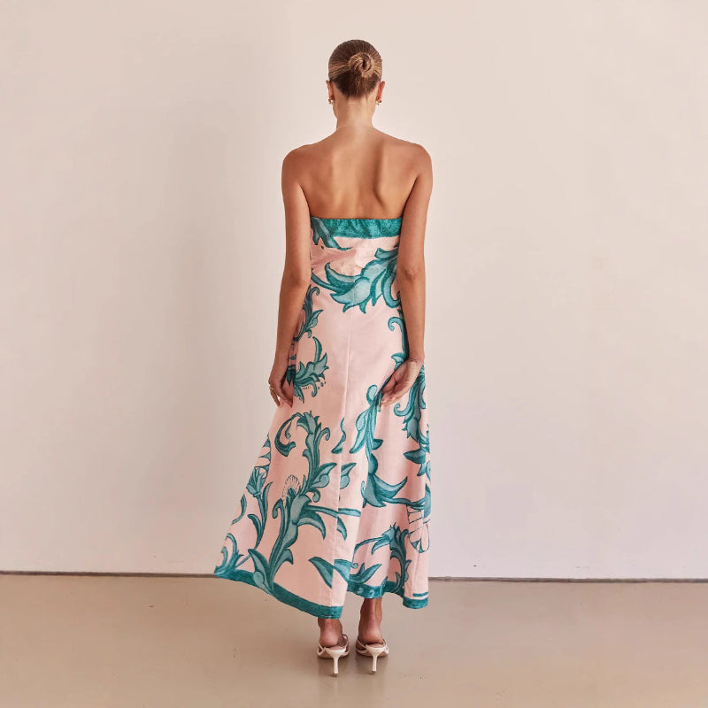 A model wearing a slim-fit, strapless, printed midi dress with a one-shoulder collar, suitable for casual wear.