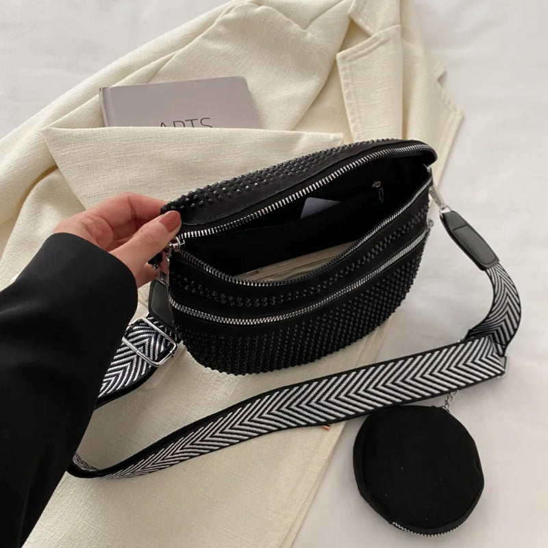 A medium-sized black crossbody bag made of PU material, adorned with metallic studs and featuring an adjustable strap.