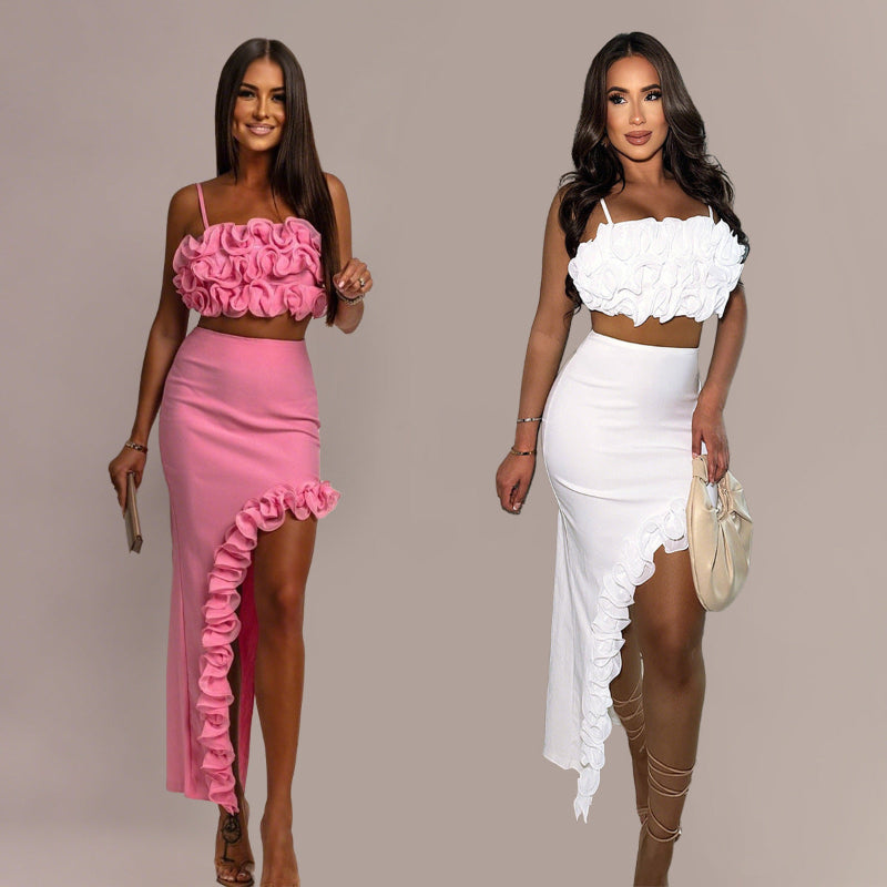 A model wearing a pink sleeveless top and a matching long skirt with a ruffle hem, part of a two-piece set.