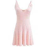 A sleeveless, V-neck, A-line mini dress in a criss-cross knitted pattern, adorned with floral appliques, available in pink and white, with a backless design.