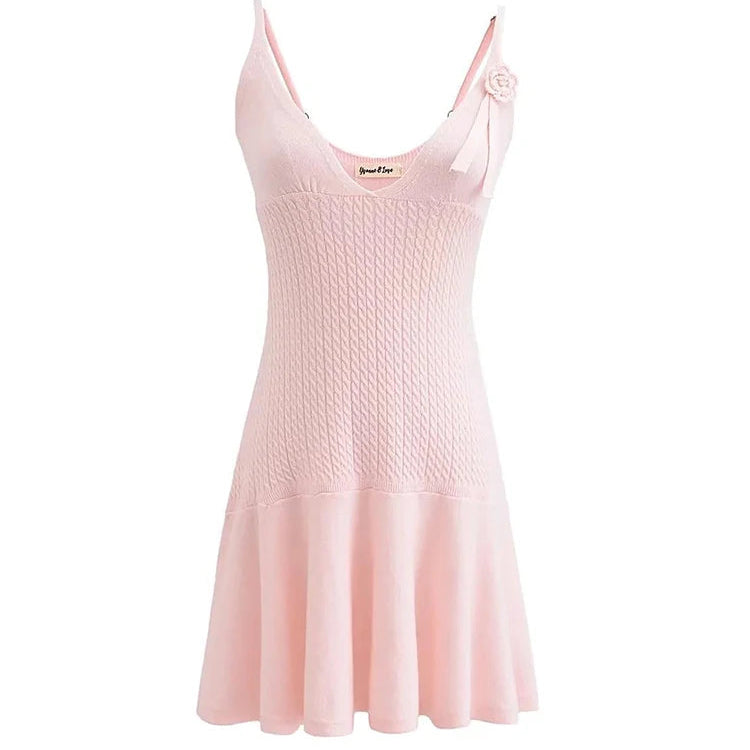 A sleeveless, V-neck, A-line mini dress in a criss-cross knitted pattern, adorned with floral appliques, available in pink and white, with a backless design.