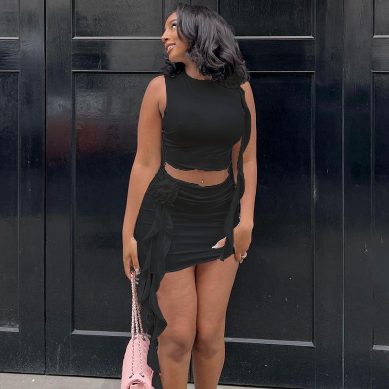  A woman wearing an embroidered flower round neck crop top and matching mini skirt set, smiling.