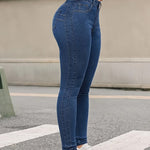A pair of blue, high-waisted, skinny-fit denim jeans for women. The jeans are made from a stretchy fabric and have a tapered leg that ends at the ankle. They are suitable for a casual style.