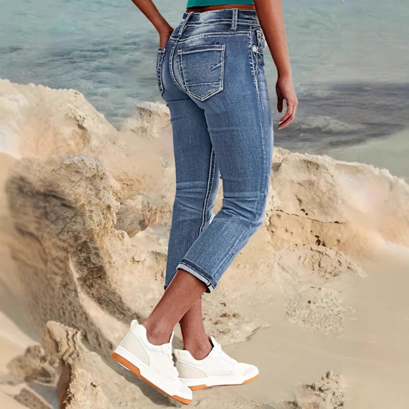 Woman wearing sky blue denim capri jeans with a flattering mid-rise fit and pocket details, standing confidently outdoors.