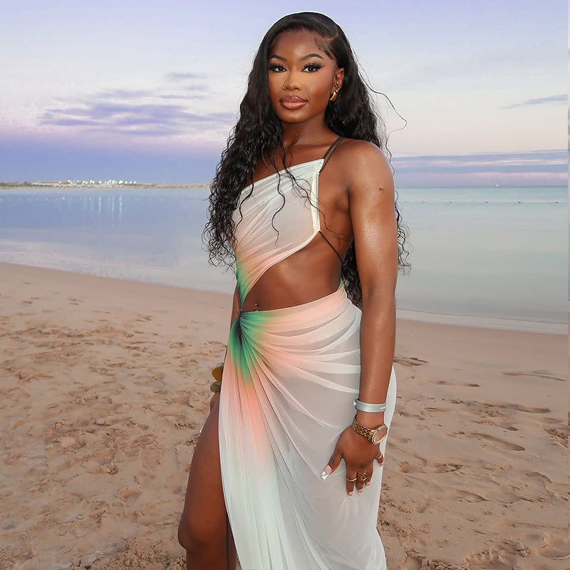 A woman wearing a white, sheer mesh midi dress with a high slit and a stylish oblique neckline. The dress is sleeveless and fitted.