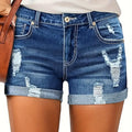 A model wearing deep blue, high-waisted denim shorts with a cuffed hem, paired with a white t-shirt. The frayed edges of the shorts are visible, and the overall style is casual and chic.