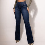 A person wearing dark blue high-waisted, button-up flared jeans, showcasing the full length and a comfortable fit.