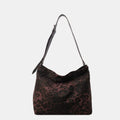 Close-up of a leopard print canvas tote bag with an adjustable strap, zipper closure, and visible interior pockets, displayed in a casual setting.