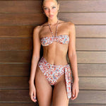 A high-waisted, tie-up bikini with a sleeveless, backless design and a floral pattern.