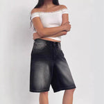 A pair of dark blue, mid-length, vintage-style denim shorts with a distressed finish. The shorts are laid flat, showcasing the straight-leg cut and medium-rise waist.