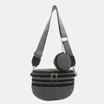 A medium-sized black crossbody bag made of PU material, adorned with metallic studs and featuring an adjustable strap.