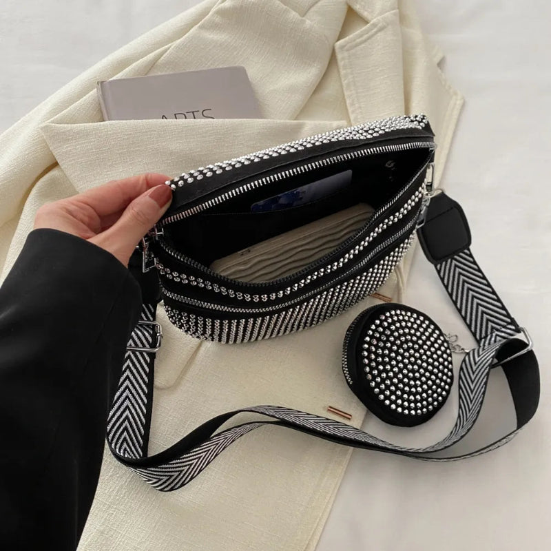 A medium-sized black crossbody bag made of PU material, adorned with metallic studs and featuring an adjustable strap.