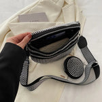 A medium-sized black crossbody bag made of PU material, adorned with metallic studs and featuring an adjustable strap.