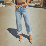 A pair of light blue, faded, straight leg high-waisted jeans for women.