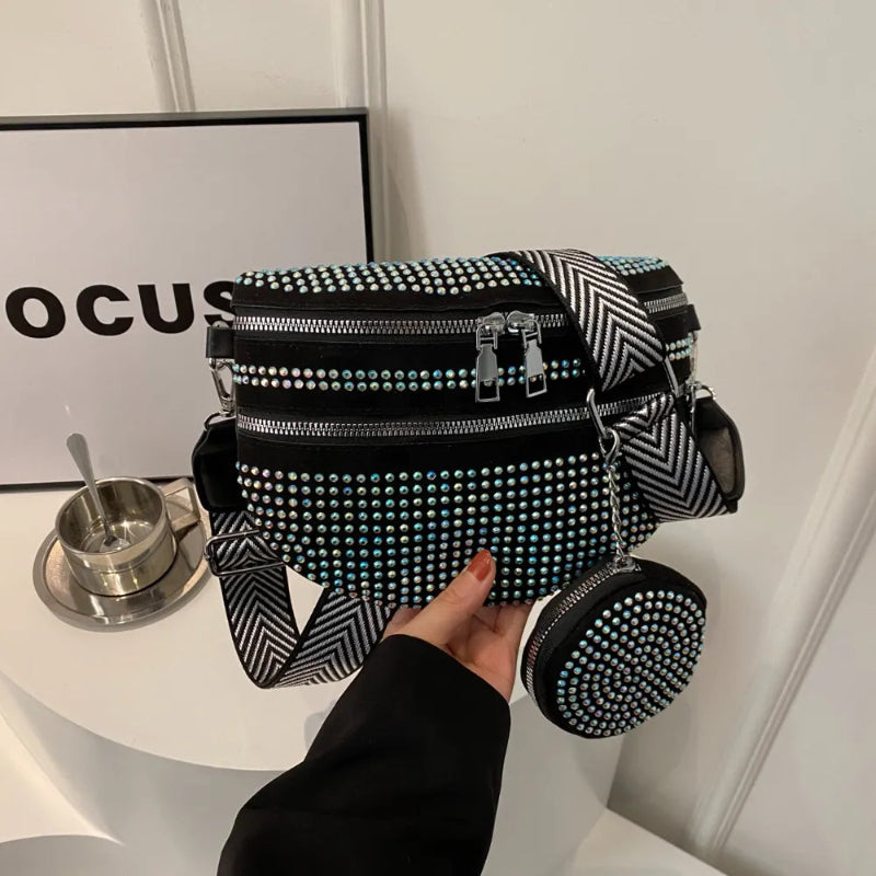 A medium-sized black crossbody bag made of PU material, adorned with metallic studs and featuring an adjustable strap.