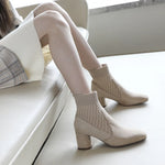  A pair of black casual lightweight ankle heel boots with a thick heel, against a neutral background