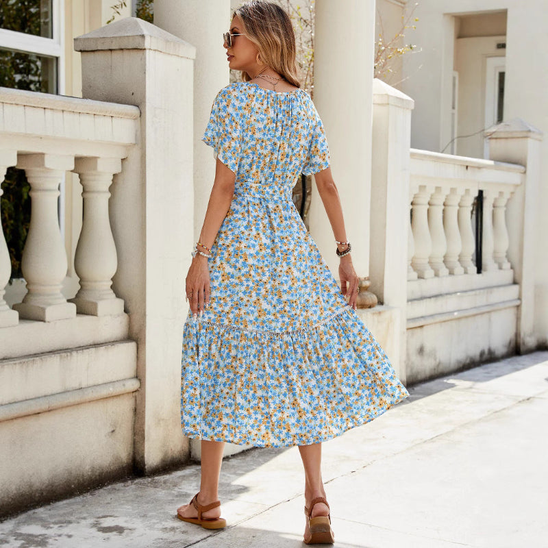A floral, A-line midi dress with a V-neck and short sleeves, shown on a model.