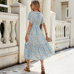A floral, A-line midi dress with a V-neck and short sleeves, shown on a model.