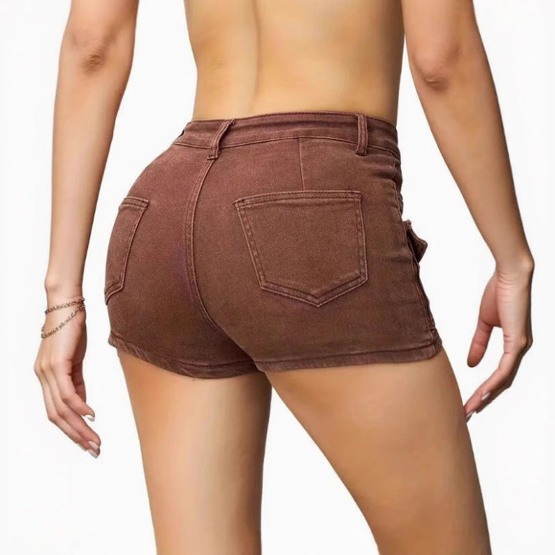 Model wearing high-waisted khaki denim shorts in street style setting, casual look with sleeveless top.