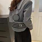 A medium-sized black crossbody bag made of PU material, adorned with metallic studs and featuring an adjustable strap.