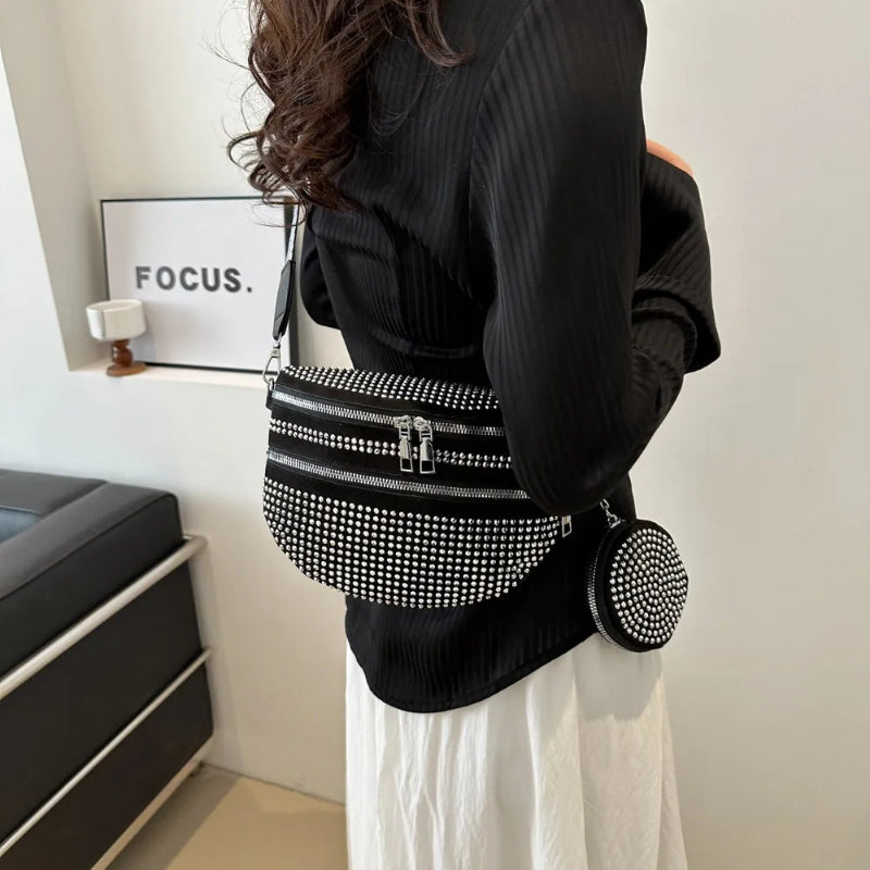 A medium-sized black crossbody bag made of PU material, adorned with metallic studs and featuring an adjustable strap.