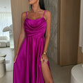 A black pleated strapless A-line midi dress with a side slit, displayed on a mannequin, highlighting its elegant design and flow.