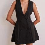 A model wearing a solid color sleeveless short V-neck dress.