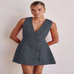 A model wearing a solid color sleeveless short V-neck dress.
