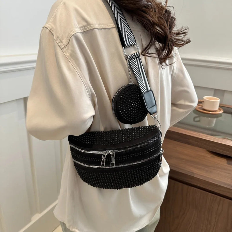 A medium-sized black crossbody bag made of PU material, adorned with metallic studs and featuring an adjustable strap.