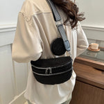 A medium-sized black crossbody bag made of PU material, adorned with metallic studs and featuring an adjustable strap.