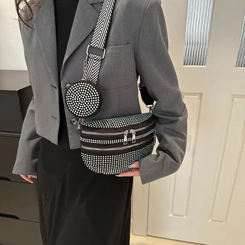 A medium-sized black crossbody bag made of PU material, adorned with metallic studs and featuring an adjustable strap.